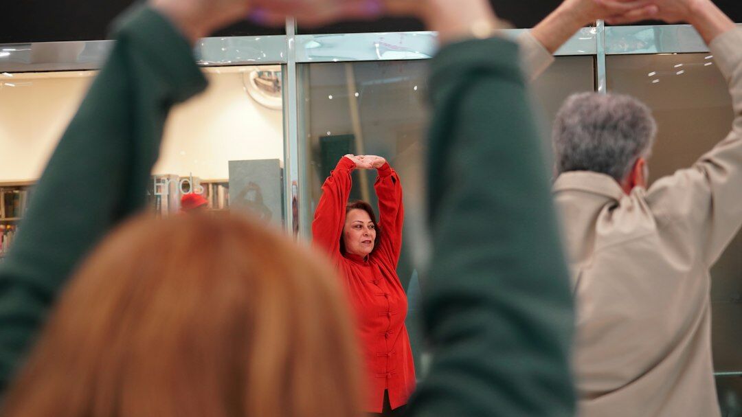 Group of seniors doing a gentle stretching exercise class indoors